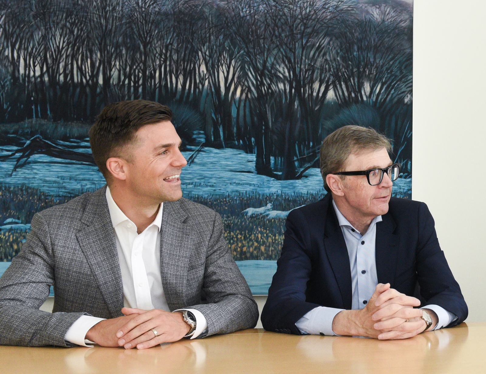 Derek Senft in conversation with a Tricor colleague at the boardroom table