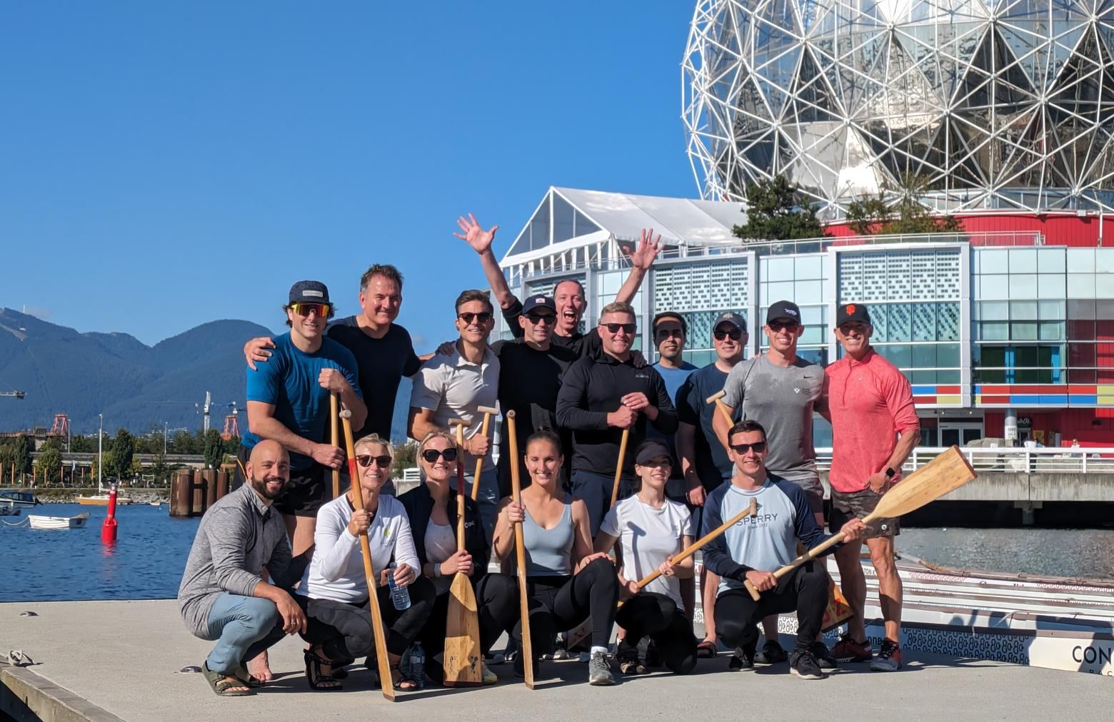 The Garibaldi Blue and Tricor team with dragon boat paddles on False Creek, Vancouver