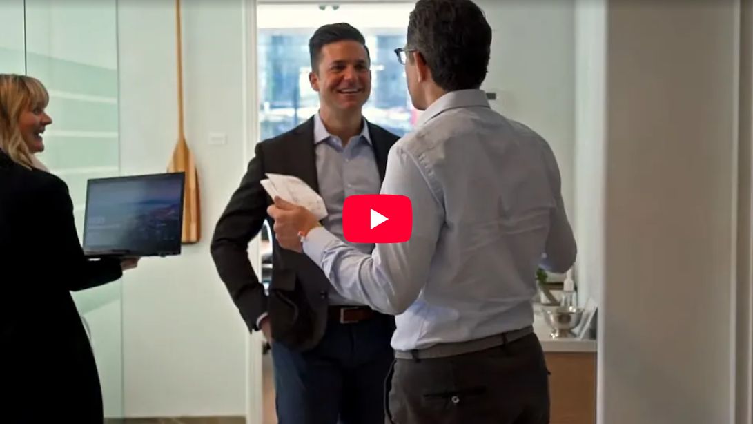 Still from the Tricor Pacific Capital video: Derek Senft talking with colleagues in the Tricor office